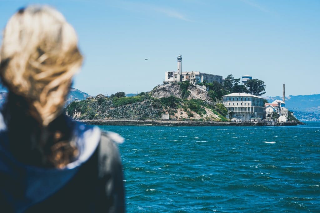 person looking at alcatraz as a boat approaches the island