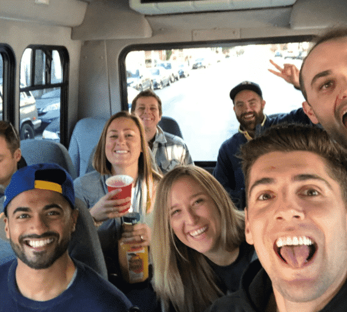 group smiling on a bus tour during team building activity