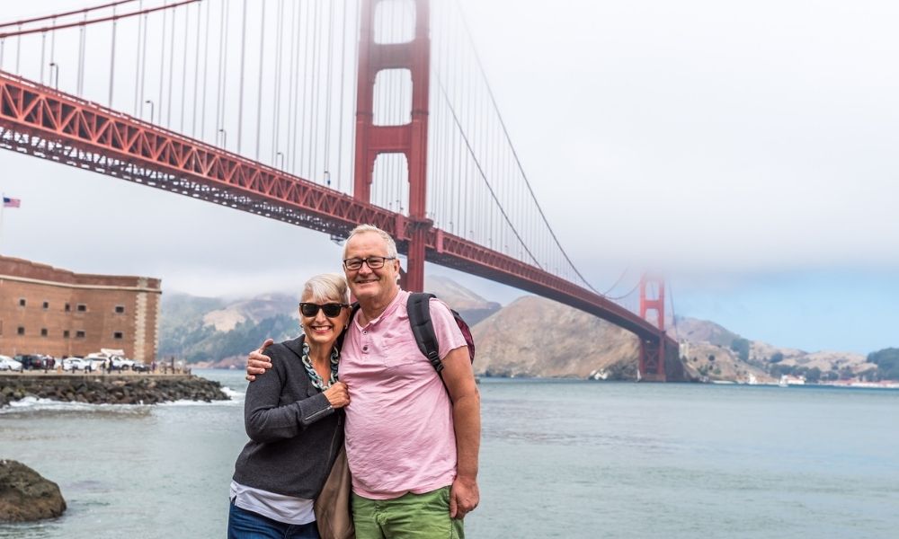 couple posing in front of foggy golden gate bridge