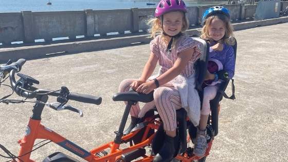 two kids on the back of an e-bike