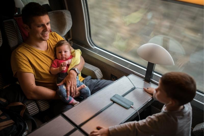 dad and two young sons riding a train