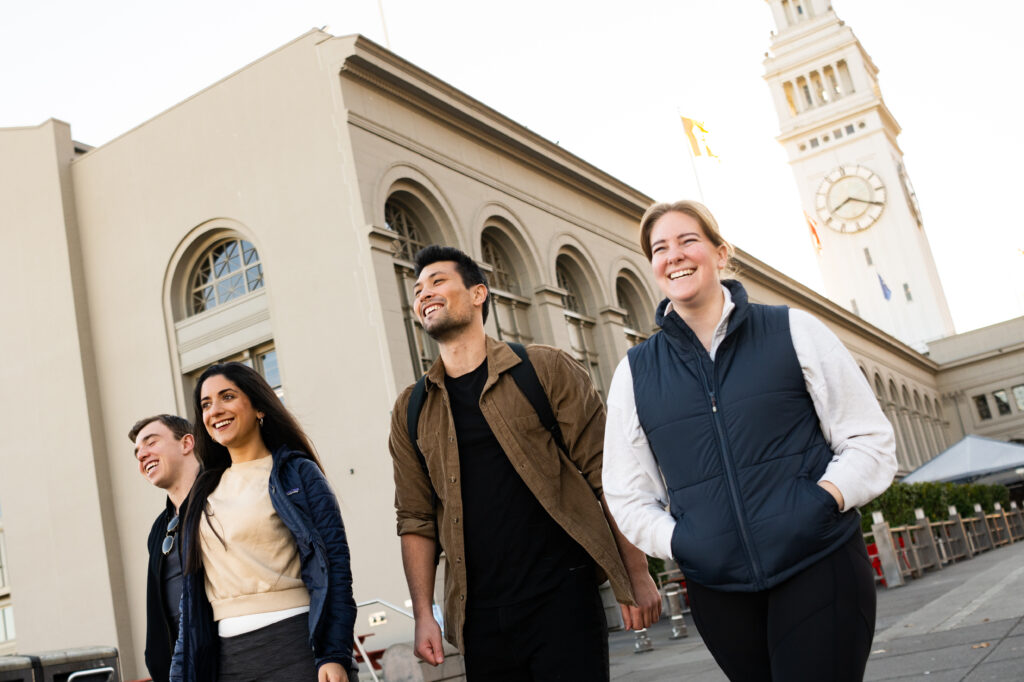 Friends smiling and walking together in San Francisco.