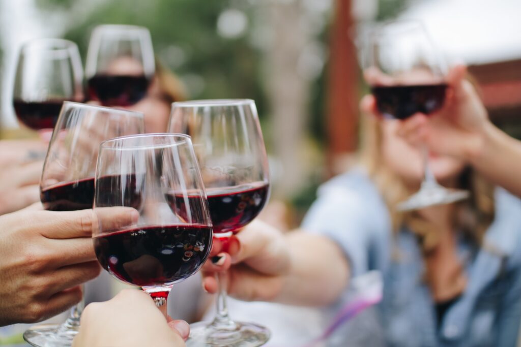 People cheers-ing their glasses of red wine together