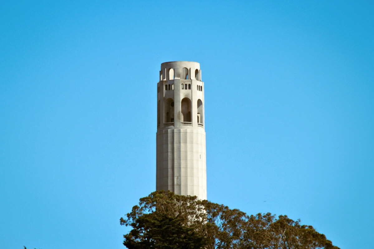 Coit Tower's distinctive cylindrical structure and observation deck against vibrant blue sky