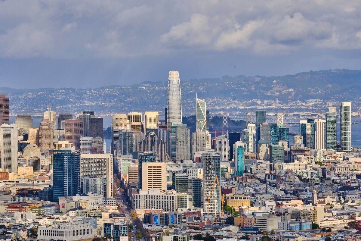 Panoramic view of San Francisco skyline featuring Salesforce Tower, Bay Bridge and densely packed downtown high-rises