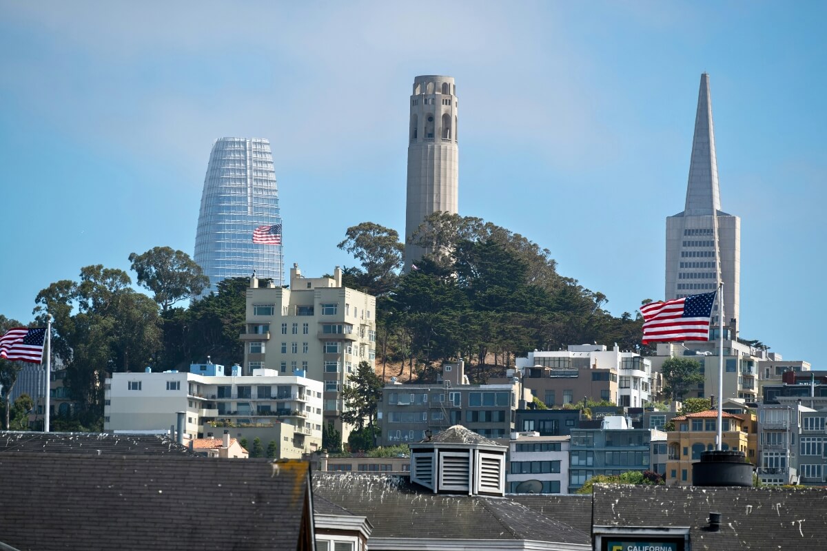 San Francisco skyline featuring Coit Tower, Salesforce Tower, Transamerica Pyramid and American flags