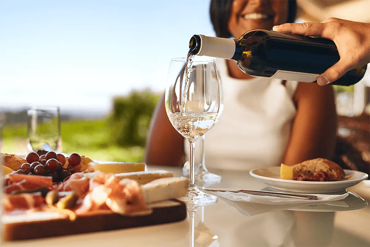 Close-up of a couple clinking wine glasses while sharing food in Napa Valley.