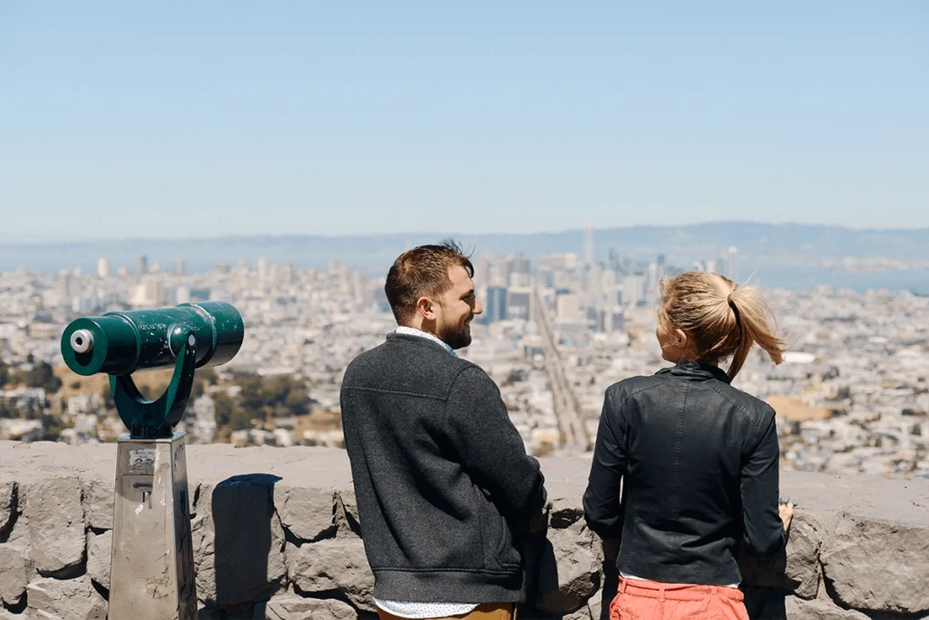 Couple standing together looking out at the San Francisco skyline from a scenic overlook