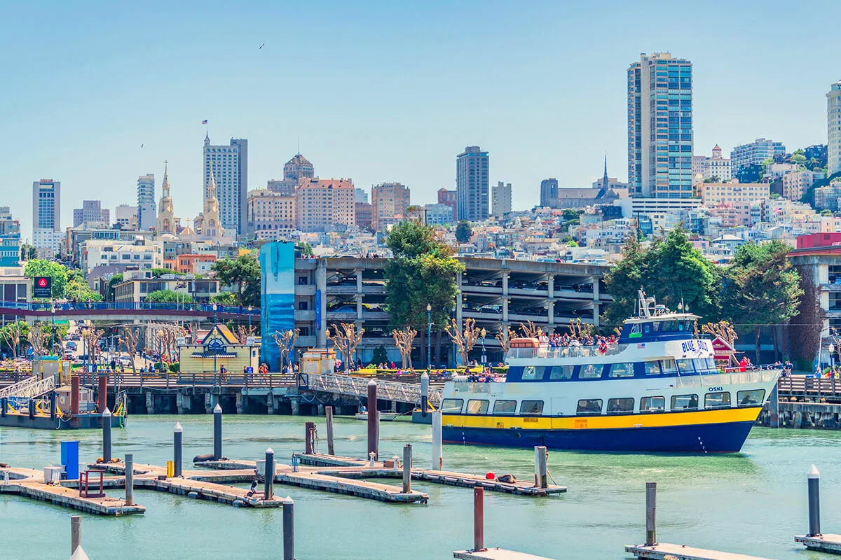 Alcatraz ferry departing Pier 33 with the San Francisco city skyline in the background.