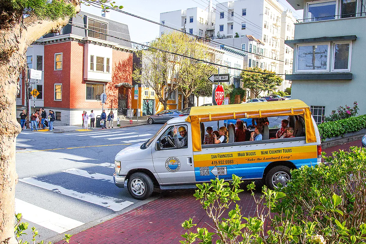 Dylan’s Tours van cruising along a classic San Francisco street, surrounded by city buildings and iconic urban scenery