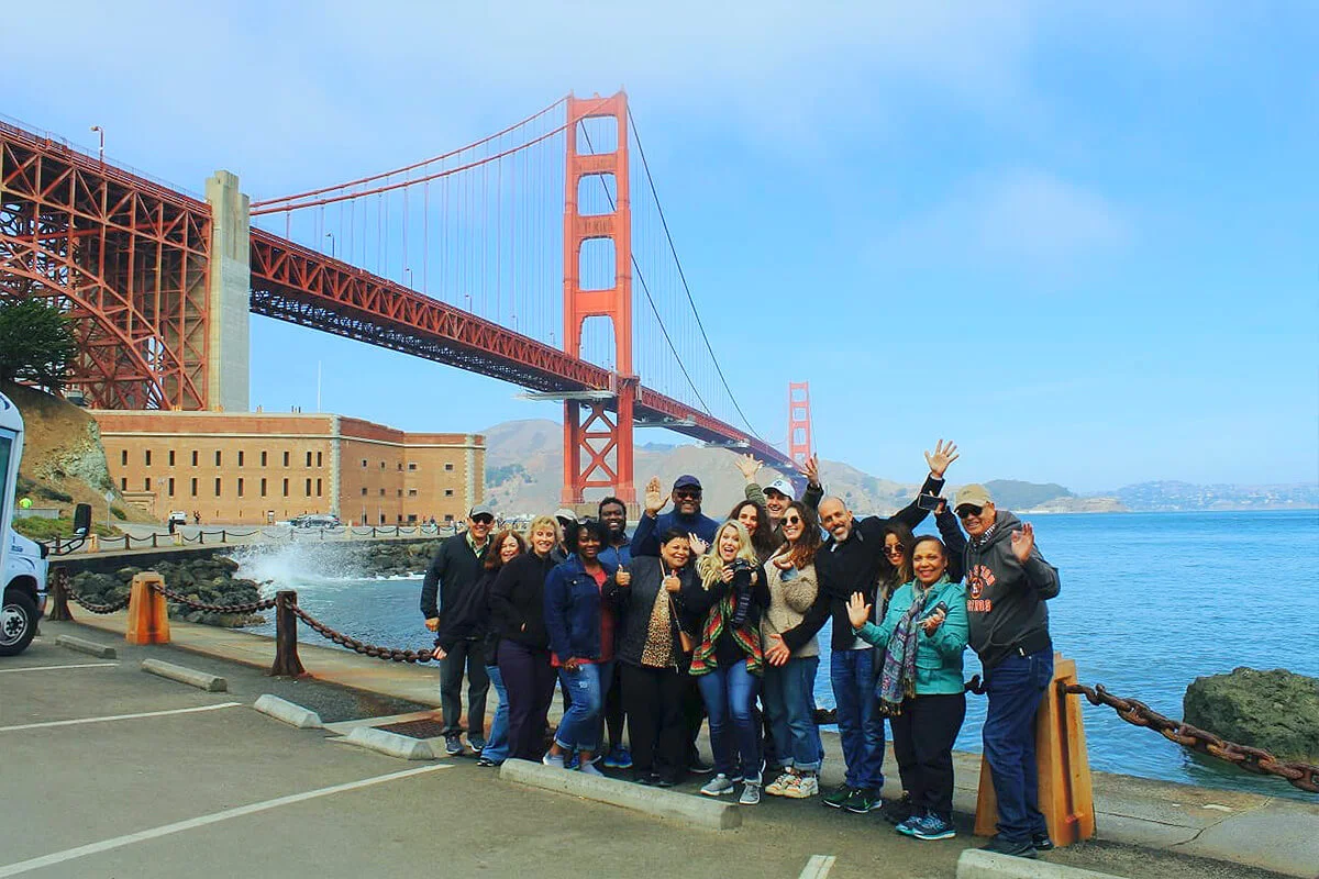 Tour group enjoying a guided experience with the Golden Gate Bridge in the background during Dylan’s San Francisco and Alcatraz tour.
