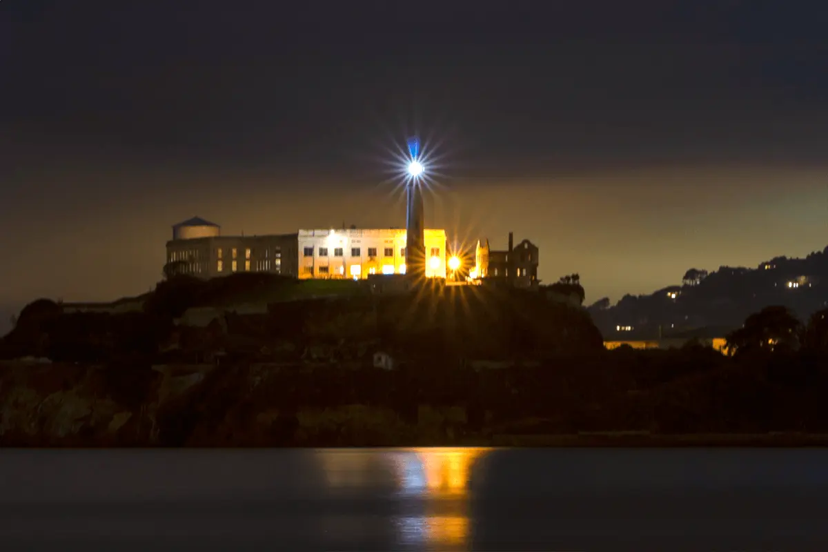 Alcatraz Island at night illuminated with lighthouse and prison building