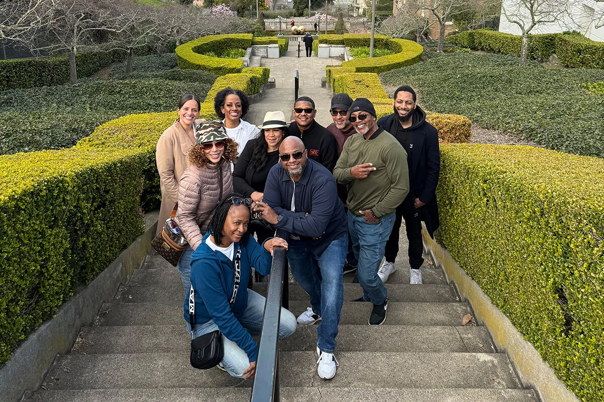 Group of friends sitting and posing on stone garden steps at a scenic park in San Francisco.