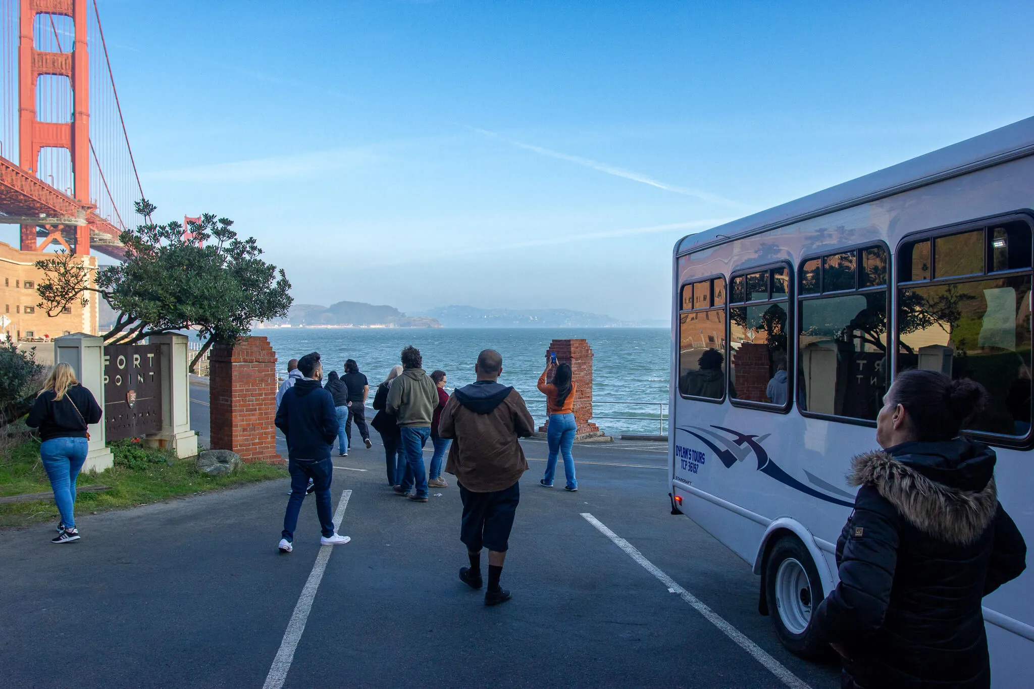 Visitors on a Dylan’s Tours stop at Fort Point, capturing views of the Golden Gate Bridge and San Francisco Bay.