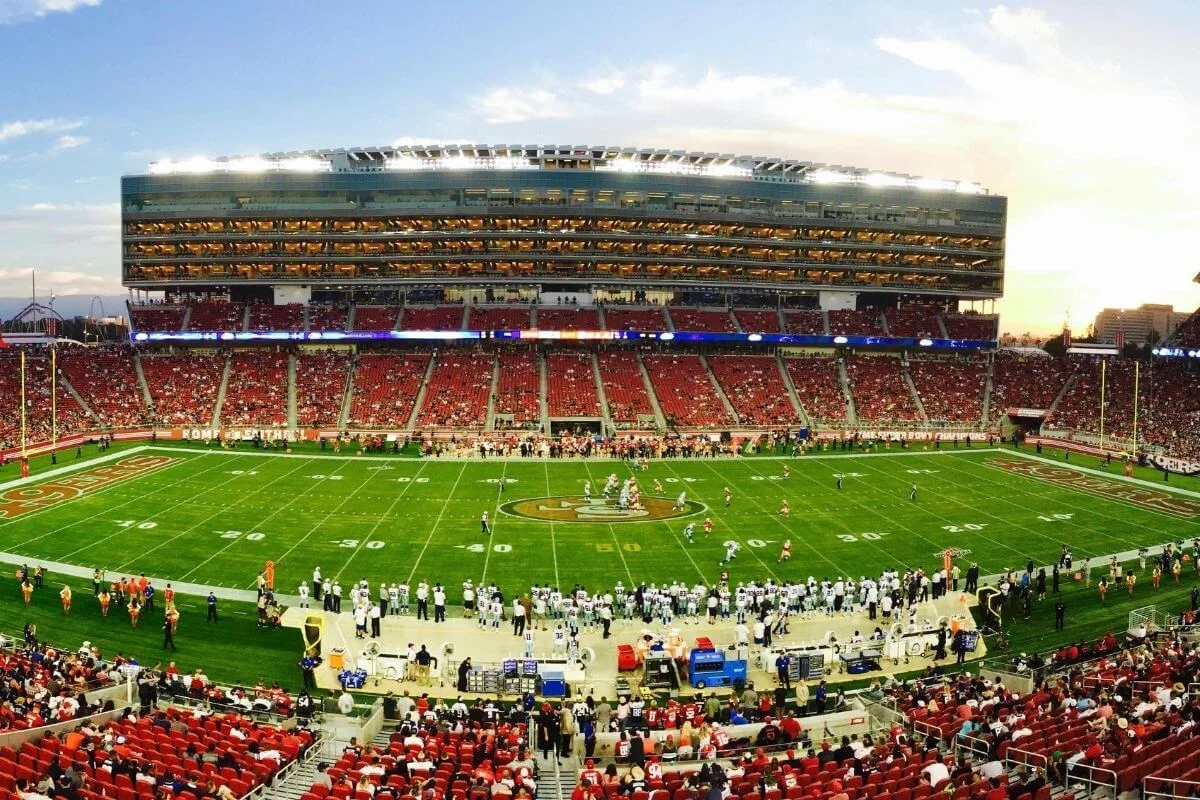 Wide view of a football game in progress at a San Francisco stadium with players on the field and fans in the stands