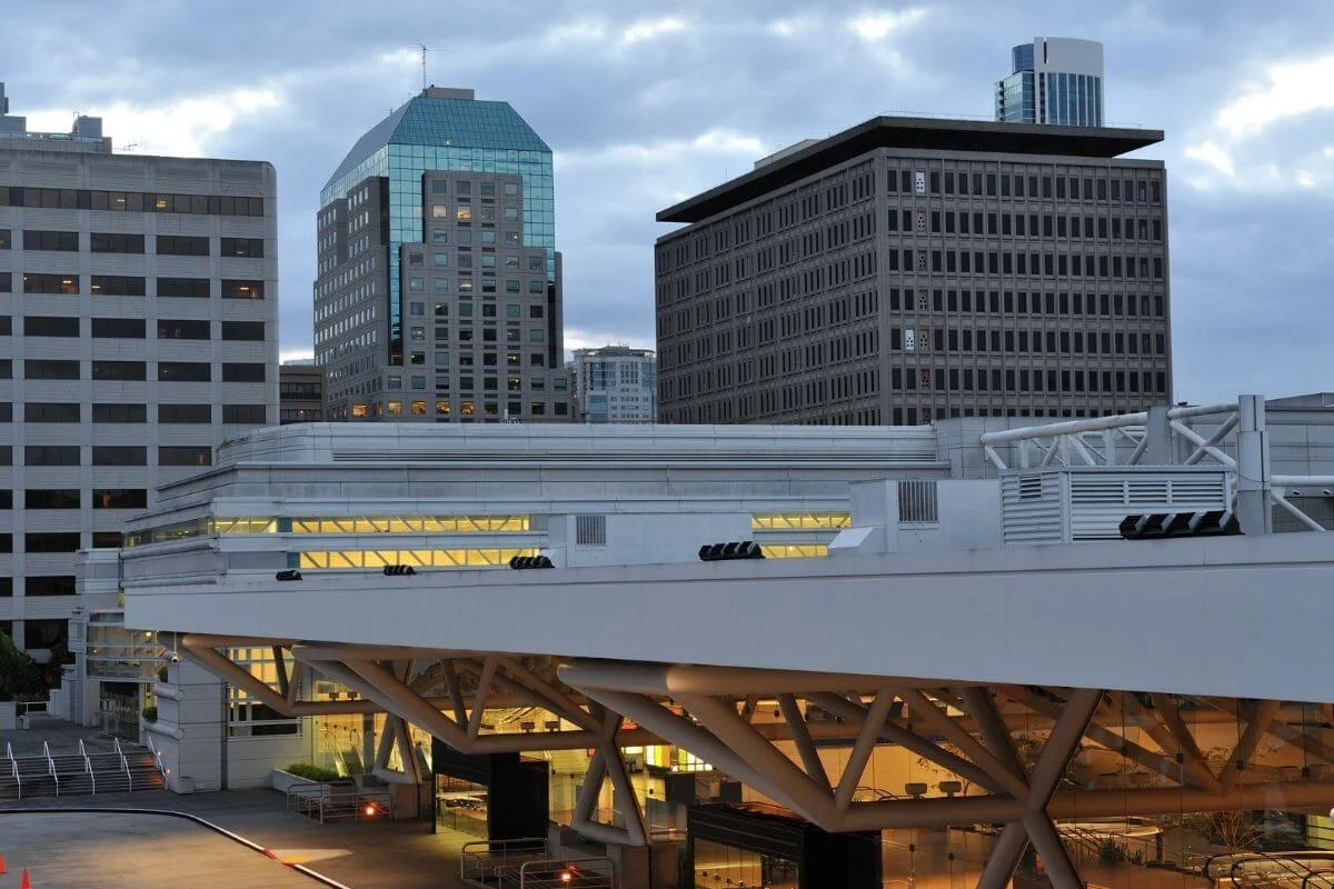 Exterior view of a modern convention center in downtown San Francisco with surrounding office buildings at dusk