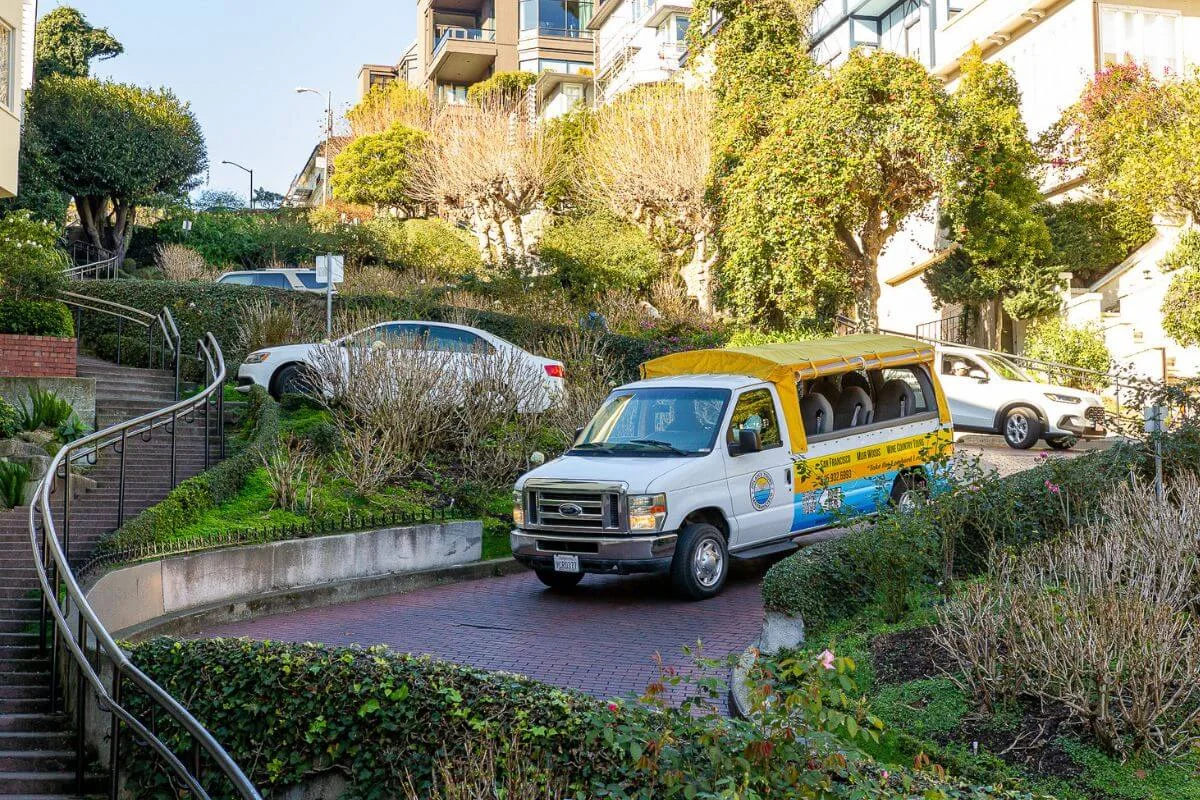 Dylan’s Tours van navigating the famous winding curves of Lombard Street in San Francisco surrounded by greenery and hillside homes