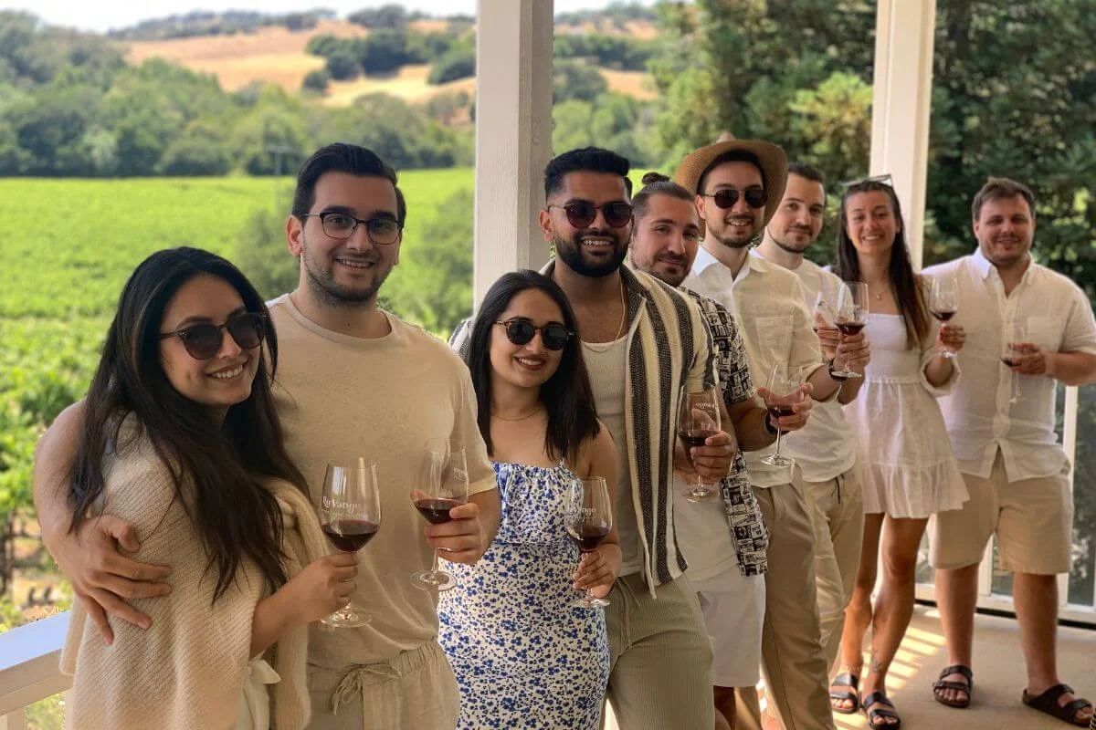 Group of friends holding wine glasses during a wine tasting at a Napa Valley vineyard terrace
