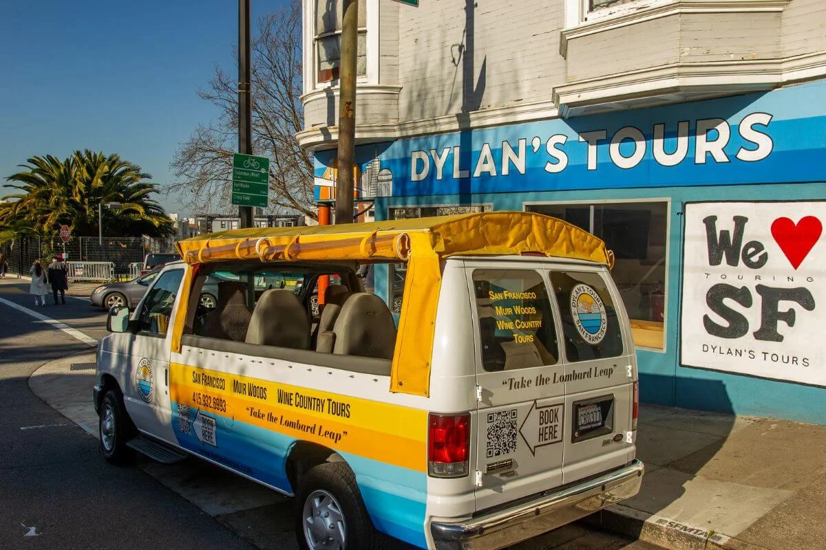 Dylan’s Tours yellow and white tour van parked outside the company storefront in San Francisco ready for city and Muir Woods tours