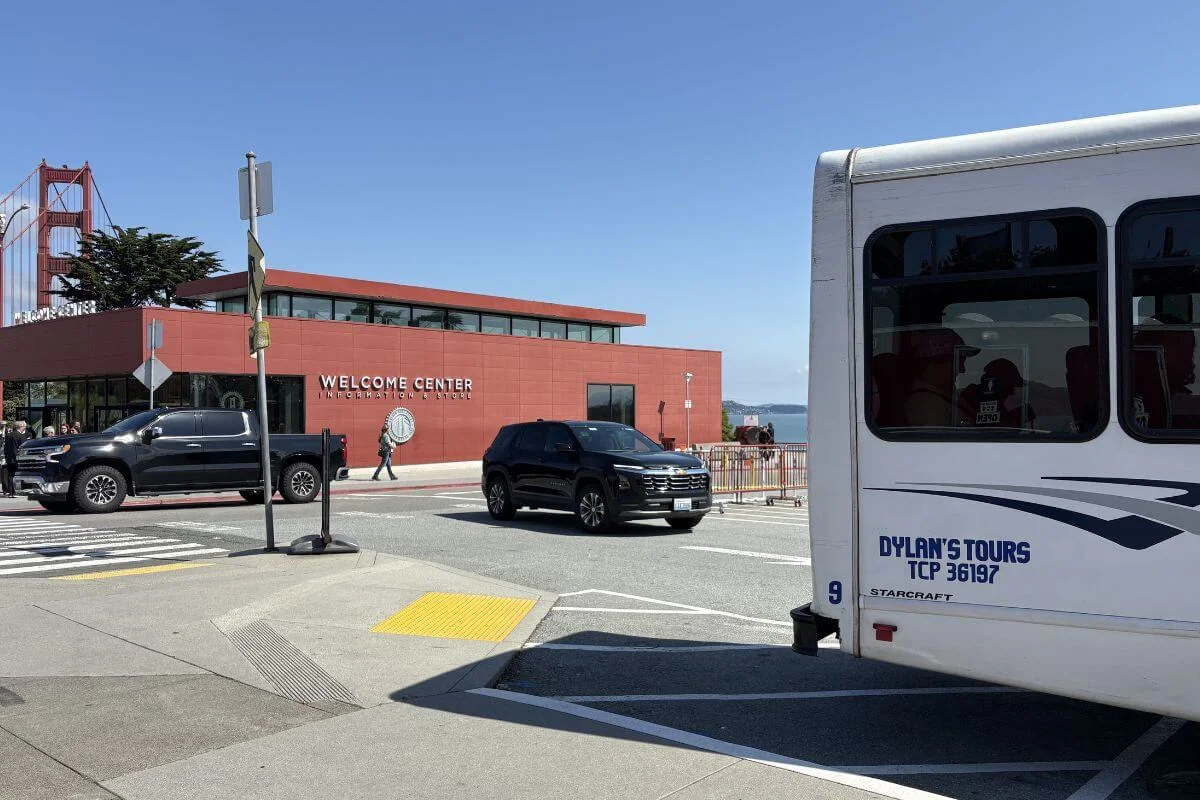 Dylan's Tours minibus parked near the Golden Gate Bridge Welcome Center in the Presidio