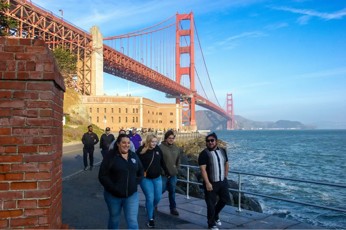 Visitors walking beneath the Golden Gate Bridge in San Francisco