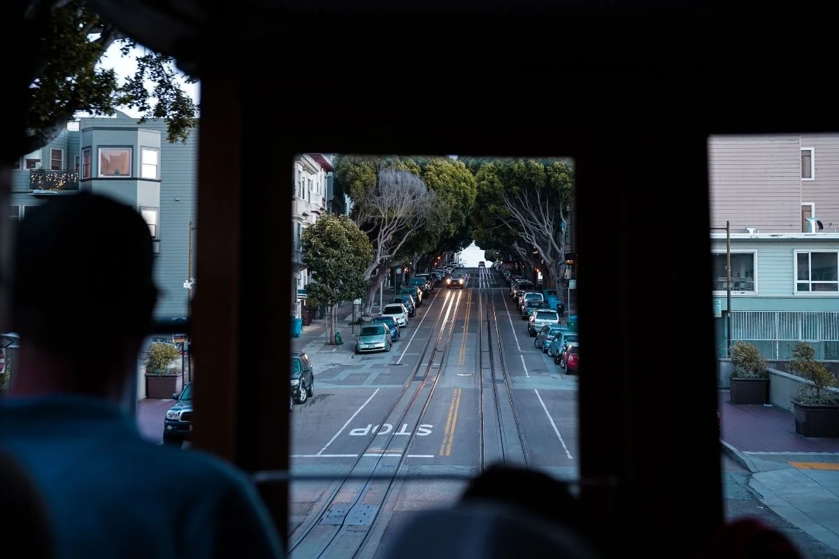 View of tree lined San Francisco street from inside cable car