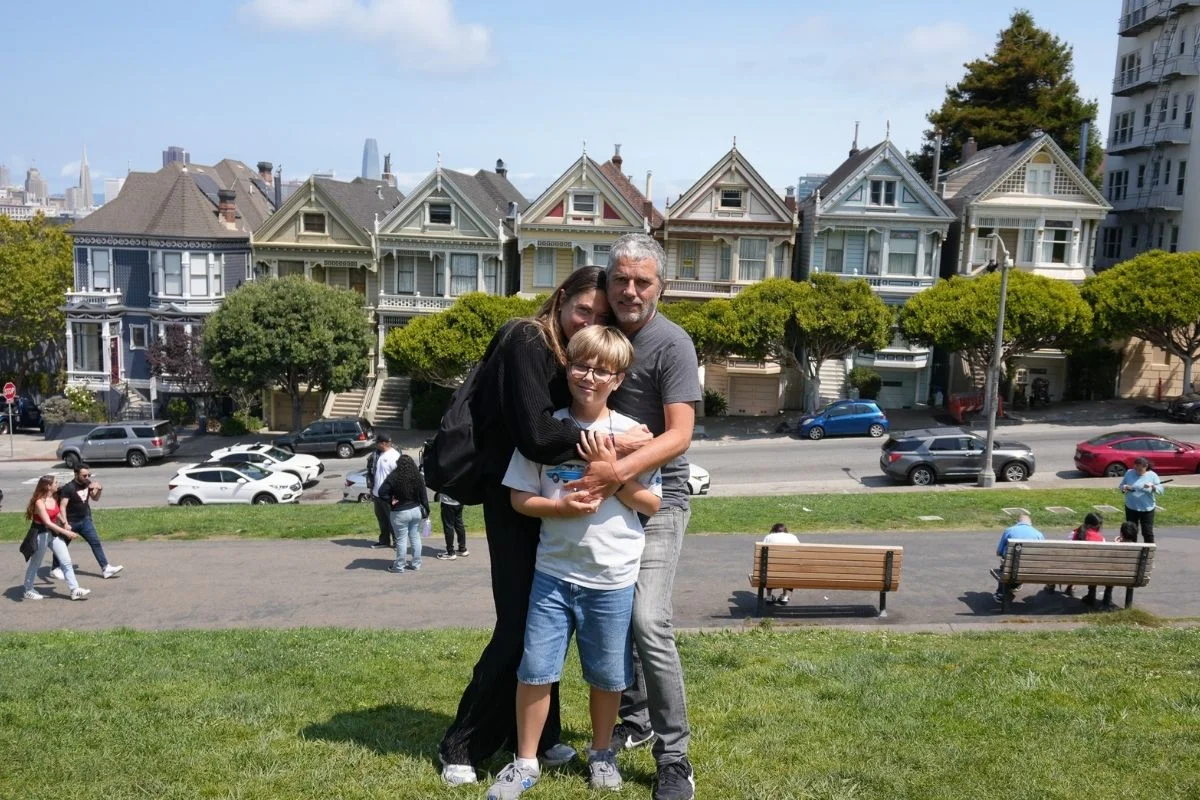 Family hugging with Painted Ladies houses in background