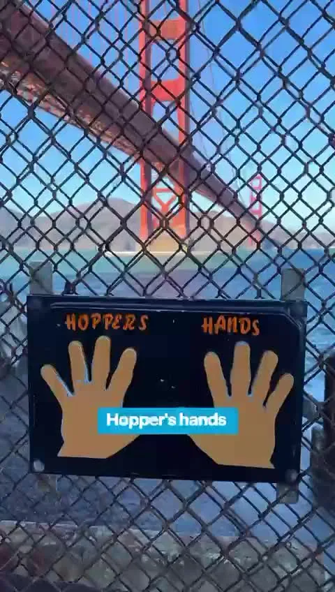 Hopper's Hands sign on the fence at Fort Point beneath the Golden Gate Bridge